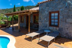 a house with a patio and a swimming pool at One bedroom villa with sea view private pool and furnished garden at Tijarafe in Tijarafe