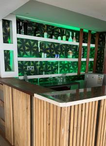 a bar with green walls and a green counter at Kantree House - Safari Suites in Kampala