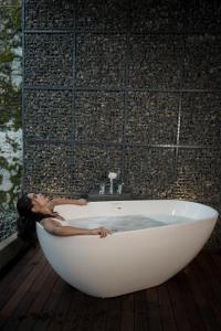una mujer está sentada en una bañera en Tea & Tranquility, en Vagamon