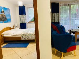 sypialnia z łóżkiem i niebieskim krzesłem w obiekcie Apartament Gęsie Piórko w Jastrzębiej Górze