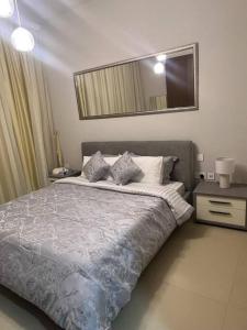 ein Schlafzimmer mit einem großen Bett und einem Spiegel in der Unterkunft Cozy room near pool muscat Bay in Bandar Jişşah