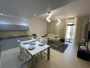 Bandar Jişşah的住宿－Cozy room near pool muscat Bay，厨房以及带桌椅的起居室。