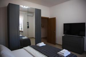 ein Schlafzimmer mit einem Spiegel, einem Bett und einem TV in der Unterkunft Doraci Home in Conversano