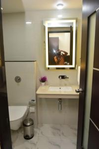 a bathroom with a sink and a mirror and a toilet at Hotel Royal Altis in Vasco Da Gama +16 photos