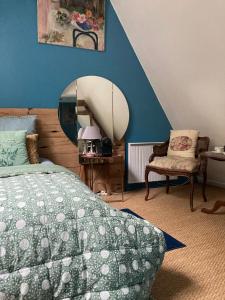 a bedroom with a bed and a mirror and a chair at Le Pigeonnier, maison d'hôtes et Spa in Croix