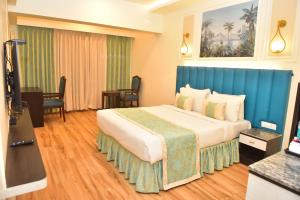 um quarto de hotel com uma cama grande e uma cabeceira azul em Hotel Royal Altis em Vasco Da Gama