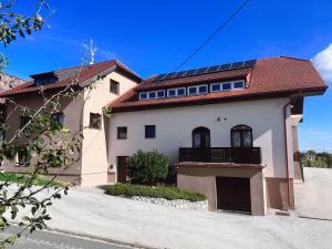 una gran casa blanca con techo rojo en Wine residence Kerman - eco-friendly apartment and rooms, en Štrigova