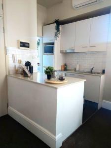 eine Küche mit weißen Schränken und einer Arbeitsplatte in der Unterkunft Perfect and modern Studio, Broadway-Chippendale in Sydney
