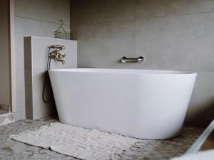 a white bath tub in a bathroom with a shower at Boutique Wine and Wellness Retreat - Wine Residence Kerman in Štrigova