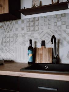 un fregadero de cocina con una botella de vino al lado en Wine residence Kerman - eco-friendly apartment and rooms, en Štrigova