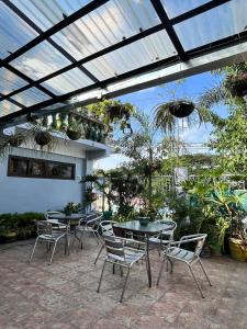 eine Terrasse mit 2 Tischen, Stühlen und Pflanzen in der Unterkunft Aladino Hostel in Dasmariñas