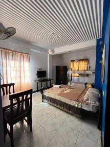 ein Schlafzimmer mit einem großen Bett und einem Schreibtisch in der Unterkunft Aladino Hostel in Dasmariñas