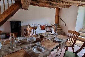 einen Tisch mit Tellern und Gläsern auf einem Zimmer in der Unterkunft Métairie du Château in Aussillon