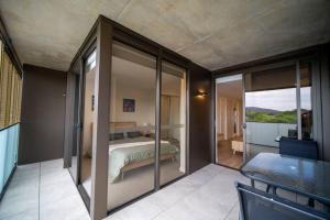 Schlafzimmer mit einem Bett und Glasschiebetüren in der Unterkunft Stay on Northbourne Ave in Canberra