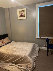 a bedroom with a bed and a window and a chair at Transformative housing Exeter Road in Nottingham