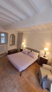 una camera con un grande letto bianco e due lampade di Casa vacanze Iris a Todi