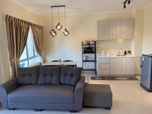 un soggiorno con divano e una cucina di Tiara Desaru Private Beach 3A12 By De Home a Bandar Penawar