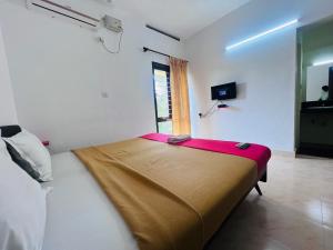 a large bed in a room with a window at Hotel Sunday - Townhouse Club Airport Trivandrum in Trivandrum