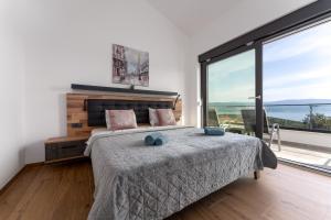 a bedroom with a large bed and a large window at Villa Rosemary -semi-detached villa with a pool and a panoramic view, close to a sandy beach - by TRAVELER tourist agency Krk in Risika +34 photos