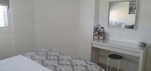 a white bedroom with a bed and a mirror at Sea view Apartment Peyia, Paphos in Paphos City +12 photos