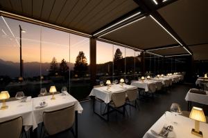 a restaurant with white tables and chairs with a view at Les Mazots du Clos in Villars-sur-Ollon