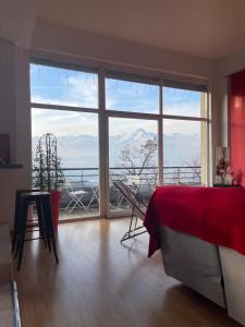a room with a large window with a view of the mountains at GLMB - Location Mont-Blanc in Saint-Gervais-les-Bains