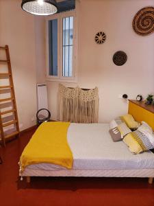 a bedroom with a bed with a yellow blanket on it at La Vie de Bohème Avignon in Avignon