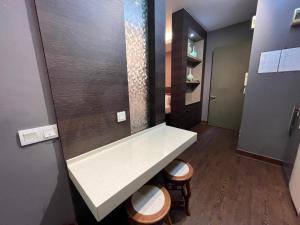 a bathroom with a white counter and two stools at Guest Studio/Suite Condominum Near Batu Caves in Batu Caves