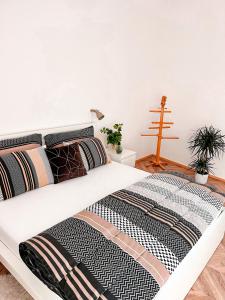 a white bed with a black and white comforter at Apartmán NIKLAN in Rožnov pod Radhoštěm