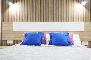 a bed with two blue pillows in a room at HAPPY ROOM in Granadilla de Abona