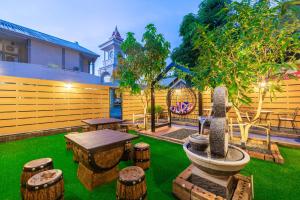 a backyard with a table and stools and a fence at Marco Polo Phuket Poshtel & Bistro in Phuket