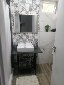 ein Bad mit einem Waschbecken und einem Spiegel in der Unterkunft Apartamento T1 46B in Lagoa