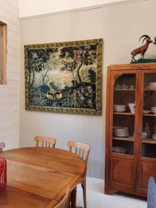 a dining room with a table and a painting on the wall at La VILLA Luchonaise in Luchon