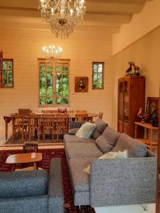 uma sala de estar com um sofá e uma sala de jantar em La VILLA Luchonaise em Luchon