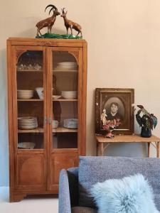 una sala de estar con un armario con platos. en La VILLA Luchonaise, en Luchon