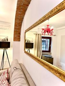 - un salon avec un canapé et un miroir dans l'établissement Rosso Verona Apartment, à Vérone