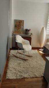 una silla blanca sentada en una alfombra en una sala de estar en Acogedor apartamento playa Usil a 600 m de la playa en Mogro