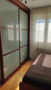 1 dormitorio con puertas correderas de cristal y 1 cama en Acogedor apartamento playa Usil a 600 m de la playa en Mogro