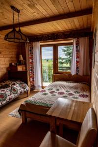 a bedroom with a bed and a table and a window at Śleboda wynajem pokoi Ewa Satoła in Biały Dunajec