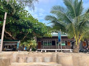 a building with a palm tree in front of it at Mama's Chalet Pulau Perhentian Besar in Kampong Pasir Hantu