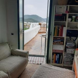 sala de estar con sofá y vistas a un balcón en Baia dei Cesari, en Bacoli