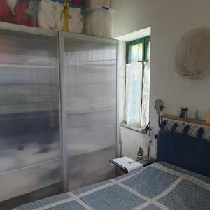 Baia dei Cesari في باكولي: غرفة نوم بسرير وخزانة زجاجية