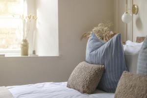 a bed with blue and white pillows and a window at NEW 2023 Central 2bed Apartment Sleeps 6 with garden in Plymouth
