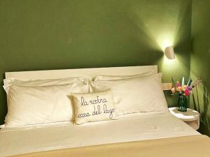 una camera con un letto bianco e una parete verde di LaLucia Luxury Suite Lake Como ad Argegno