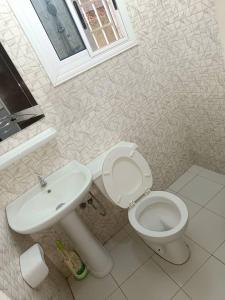 een badkamer met een toilet en een wastafel bij TOTSI New World in Lomé