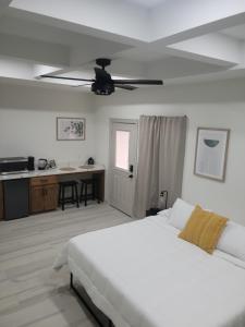 Schlafzimmer mit einem weißen Bett und einem Deckenventilator in der Unterkunft 1 Bedroom suite close to Bert Ogden arena in Edinburg