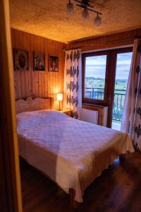 a bedroom with a large bed and a large window at Śleboda wynajem pokoi Ewa Satoła in Biały Dunajec