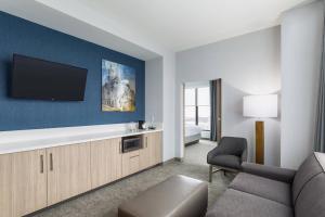 a living room with a couch and a tv at SpringHill Suites St. Paul Downtown in Saint Paul