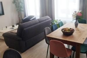 a living room with a couch and a table with a bowl of fruit at Maison de la Lys in Aire-sur-la-Lys