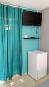 a room with a blue curtain and a refrigerator at Le Caferoom Club in Tsingoni